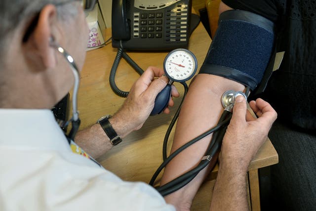 <p>A GP taking a blood pressure reading </p>