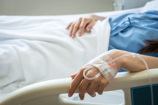 <p>A woman rests in a hospital, receiving intravenous fluid a vein in her hand. Amid a nationwide shortage of the fluid following damage to a plant in North Carolina during Hurricane Helene, hospitals across the country are taking action to deal with the shortage</p>