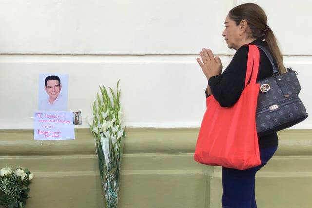 <p>A supporter of slain Mayor Alejandro Arcos prays at the entrance of the municipal building one week after he took office</p>