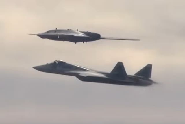 <p>An earlier version of the Okhotnik combat drone (above) flies alongside an Su-57 jet</p>
